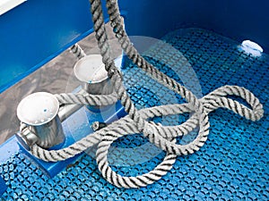 Coiled rope on a blue sailing boat deck. Sailing equipment aboard ship. Shipping concept