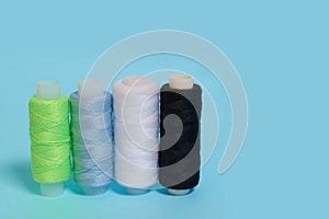 Coils with black, white, blue and green threads on a blue background