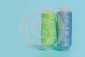 Coils with blue and green threads on a blue background