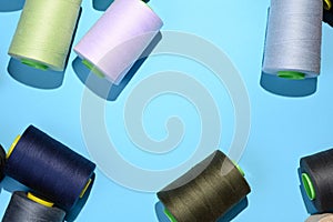 Coils of multicolored threads on blue fabric background