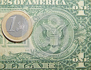 Coin 1 euro against a paper dollar