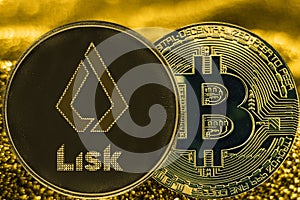 Coin cryptocurrency bitcoin BTC and lisk token on golden backgr