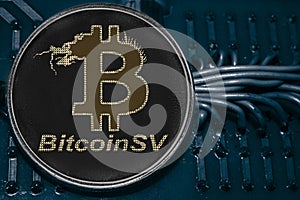 Coin cryptocurrency Bitcoin SV on the background of wires and circuits. BSV