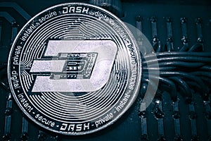 Coin cryptocurrency Dash on the background of wires and circuits.