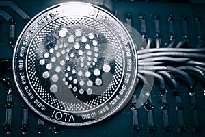 Coin cryptocurrency iota on the background of wires and circuits. altcoin miota