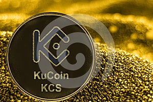 Coin cryptocurrency KCS KUcoin token on golden background.