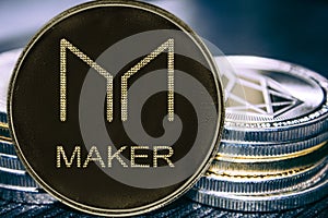 Coin cryptocurrency Maker on the background of a stack of coins. MKR