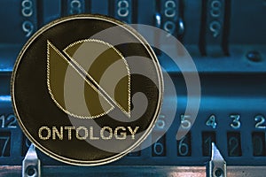 Coin cryptocurrency Ontology ONT against the numbers of the arithmometer. photo