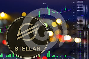 Coin cryptocurrency Stellar XLM on night city background and chart.