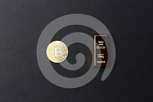 A coin of gold bitcoin next to a gold bar. Bitcoin Conservation. Cryptocurrency. Close-up. Virtual money. Copy space