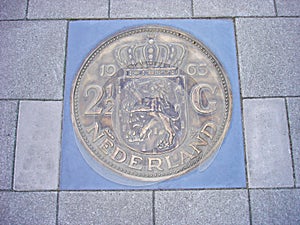 Coin of 2,5 guilders in pavement photo