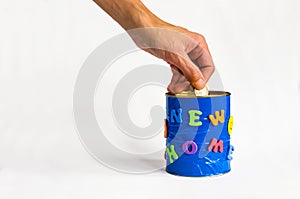 Coin insert into a handmade money box with New home inscription on a white background. Front view