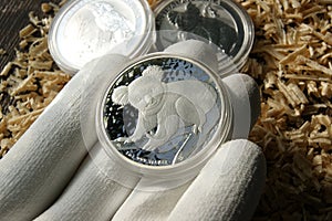 Coin in numismatist's hand. Investment pure silver coin. Australian 1 Dollar koala.
