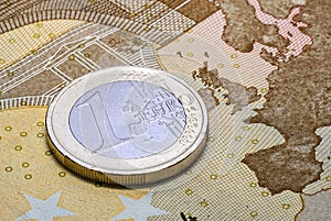 Coin one euro on the fifty euros banknote