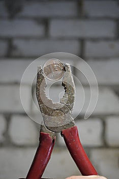 Coin one Russian ruble clamped in a pliers