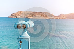 Coin operated binocular looking to the sea and Spinalonga Island on Crete, Greece