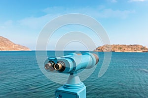 Coin operated binocular looking to the sea and Spinalonga Island on Crete, Greece