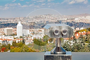 Coin operated binocular viewer at the terrace floor of Atakule in front of blurry Ankara view