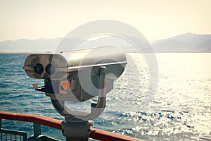 Coin operated binoculars viewer in front of the sea landscape