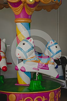 A coin operated kiddie ride cute pony character displayed at the entrance of a store