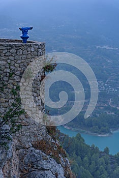 Coin operated viewer look at the Reservoir of El Castell de Guadalest, Alicante, Spain. Sheer wall Evening time