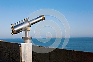 Coin operated viewfinder telescope overlooking sea
