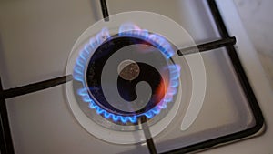 Coin, russian ruble in burning gas on the stove in the dark. Concept