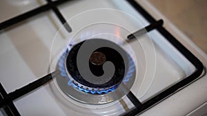 Coin, russian ruble in burning gas on the stove in the dark. Concept