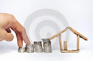 Coin stack and house miniature  on white