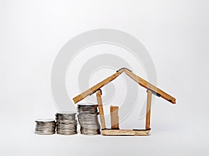 Coin stack and house miniature  on white