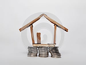 Coin stack and house miniature  on white