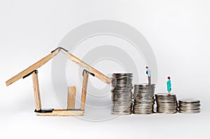 Coin stack,miniature people  and house miniature isolated on white