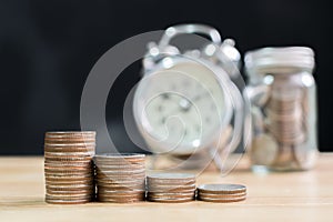 Coin stack step up increase save money with blurred clock and jar background, Finance and investment concept