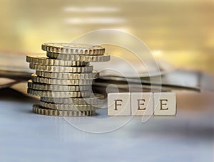 Coin stack and wooden blocks with the fee text.