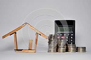 Coin stacks, calculator and house miniature