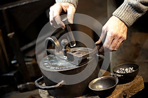 Coinage craftsman stamping coins with hammer and anvil.