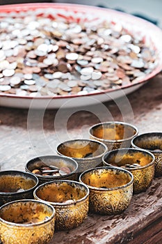 Coins as a gift. Some decorated yellow bowls containing coins donated for charity.