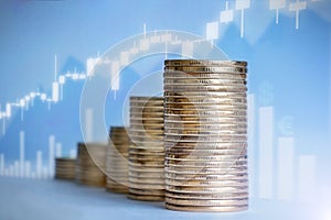 coins on a blue background, on the photo are various graphs showing profit growth. horizontal photo, close-up of coins.