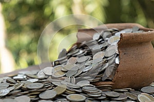 Coins in broken jar from on pile lots coin with blurred background, Money stack for business planning investment and saving