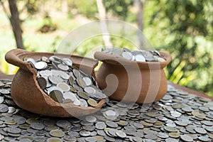 Coins in broken jar from on pile lots coin with blurred background, Money stack for business planning investment and saving