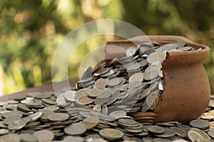 Coins in broken jar from on pile lots coin with blurred background, Money stack for business planning investment and saving