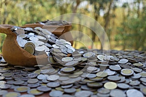 Coins in broken jar from on pile lots coin with blurred background, Money stack for business planning investment and saving