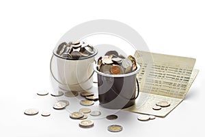 Coins in buckets and saving account passbook, book bank on white