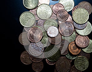 Bulk of european coins from topview on black background with copy space photo