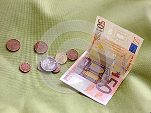 Coins and Cash on greenish Background