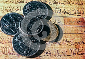 Coins of dinars, Kuwait national currency and lines from the Quran