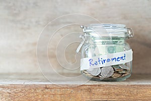 Coins and dollar bills in glass jar with retirement label