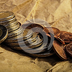 Coins of euro cents and two euros lie on the background of coins