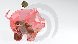 Coins fall into a pink glass piggy bank - a symbol of wealth, frugality and effective investment planning and business. Symbol of