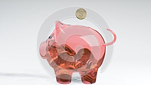 Coins fall into a pink glass piggy bank - a symbol of wealth, frugality and effective investment planning and business. Symbol of